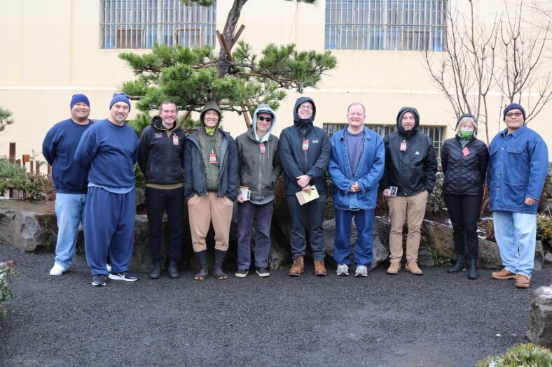 A group of Portland Japanese Garden employees posing for a photo taken at the Memorial Healing Garden at Oregon State Penitentiary.