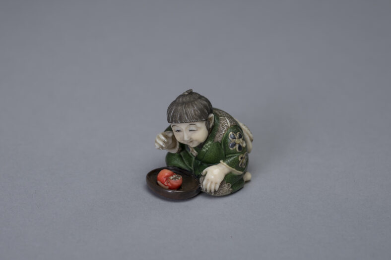 Japanese Netsuke miniature ivory sculpture depicting a boy with a Daruma.