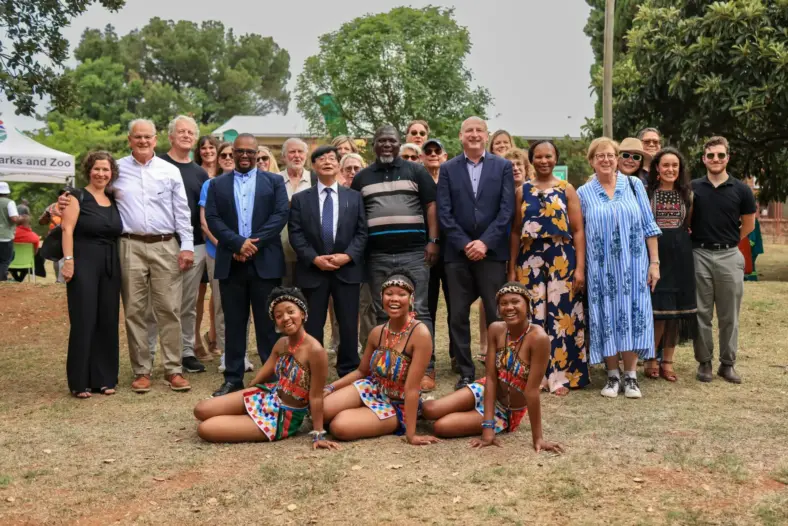 A group of people pose for a camera, after the planting of a tree donated by Japan Institute to the Johannesburg Botanical Garden.