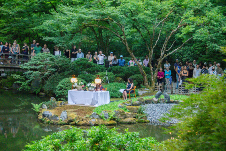 People gathered listening to the lotus sutra during O-Bon, a festival held annually at Portland Japanese Garden.