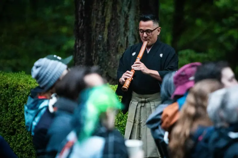 A shakuhachi performer plays for an audience at Portland Japanese Garden.