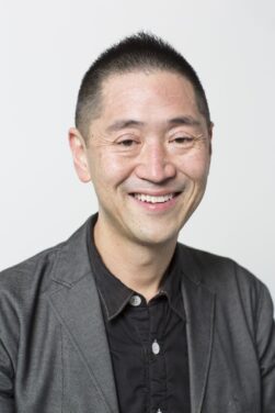 Headshot of Ken Oshima on a grey background
