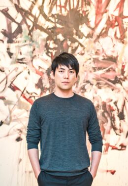 Shohei Shigematsu portrait in front of abstract painting wearing a green shirt