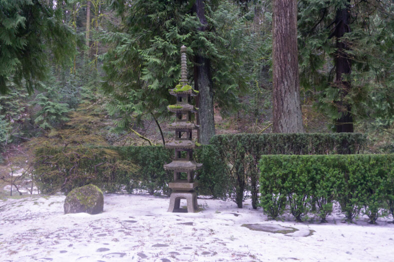 A tall stone lantern in Portland Japanese Garden stylized to look like a pagoda.
